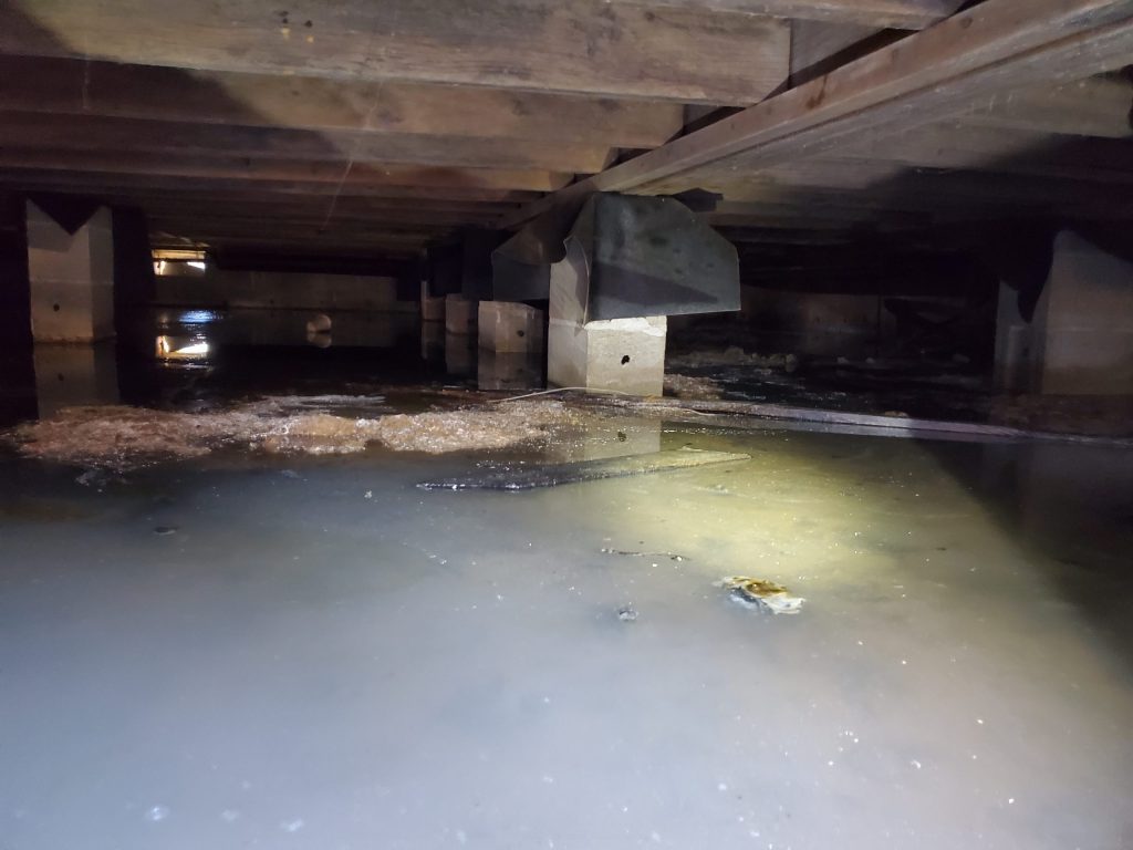 Standing water in a flooded crawl space after a Louisville storm