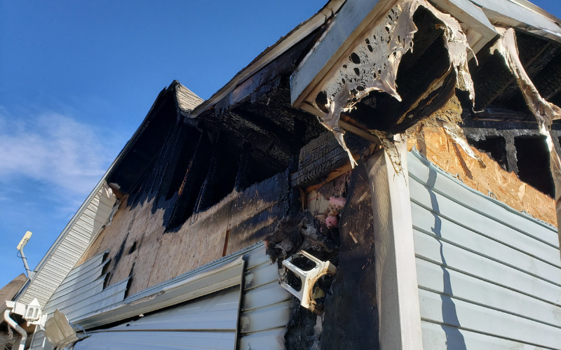 Exterior of a Louisville house with fire damage to roof and siding